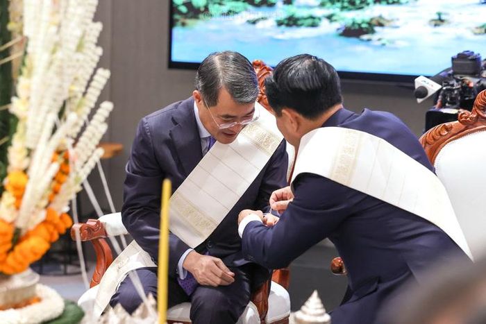 Thủ tướng Chính phủ Lào Saleumxay Kommasith buộc chỉ cổ tay cho Thủ tướng Chính phủ Lê Minh Hưng - Ảnh: chinhphu.vn/Nhật Bắc