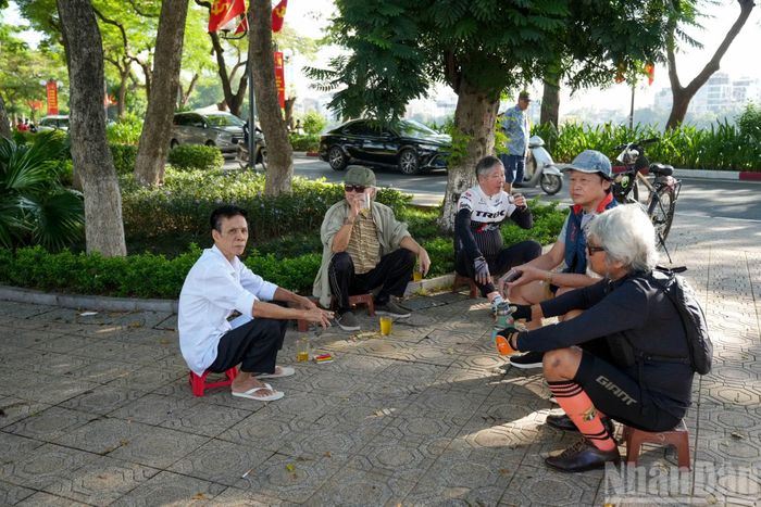 Tại Hồ Tây lộng gió, nhiều người tranh thủ thời tiết dễ chịu, vừa trò chuyện, vừa thong thả thưởng thức một ly trà nóng bên hồ.