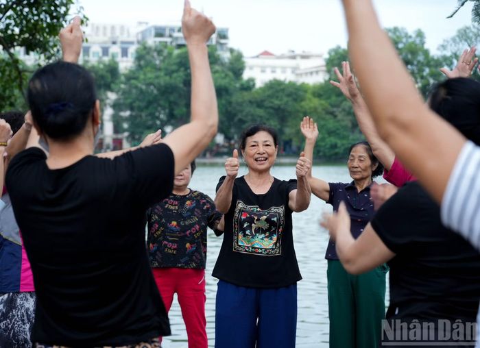 Duy trì thói quen tập thể dục quanh hồ đã nhiều năm, cô Đào (60 tuổi, đứng giữa) cho biết, những ngày này thời tiết Hà Nội đẹp nhất trong năm, tiết trời se lạnh đầu mùa khiến việc vận động buổi sáng trở nên dễ chịu hơn nên cô không bỏ lỡ một buổi tập nào.