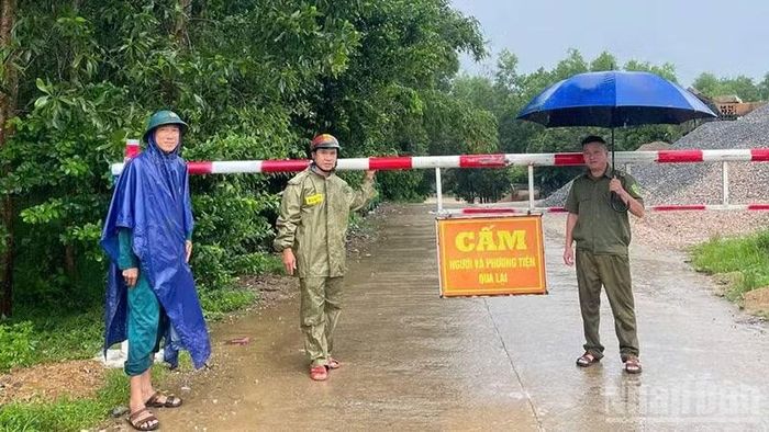 Lực lượng chức năng xã Sơn Cẩm Hà dựng chắn barie tại cầu Tiên Châu khi cầu bị ngập. (Ảnh: SCH)
