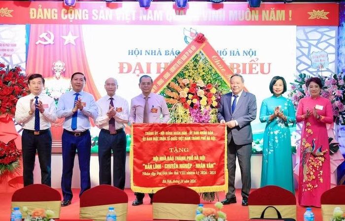 Lãnh đạo Thành ủy Hà Nội tặng bức trướng của thành phố Hà Nội chúc mừng Hội Nhà báo thành phố Hà Nội. (Ảnh: THÁI QUANG)