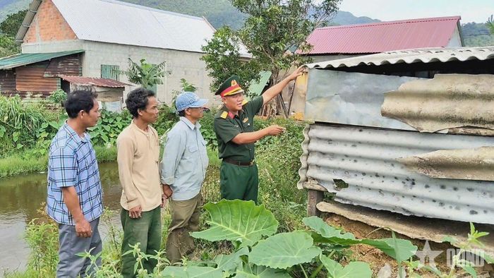 Cán bộ Đoàn Kinh tế - Quốc phòng 92 (Quân khu 4) hướng dẫn người dân làm chuồng trại chăn nuôi. 