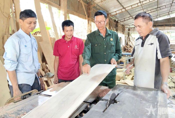 Cựu chiến binh Cao Tiến Trung (thứ hai, từ phải sang) trao đổi với công nhân.