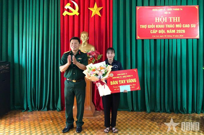 Trung tá QNCN Nguyễn Văn Mai, Phó đoàn trưởng Đoàn Kinh tế - Quốc phòng 74, Binh đoàn 15, Trưởng ban tổ chức hội thi trao danh hiệu "Bàn tay vàng" cho chị Cao Thị Đức, công nhân Đội 16.
