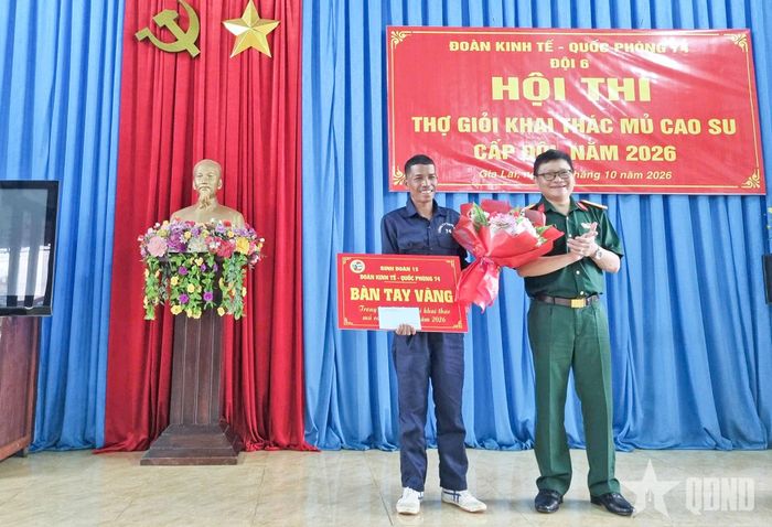 Trung tá Cao Hữu Dạ Từ, Phó đoàn trưởng Đoàn Kinh tế - Quốc phòng 74 trao danh hiệu "Bàn tay vàng" cho anh Ksor Mác, công nhân Đội 6.
