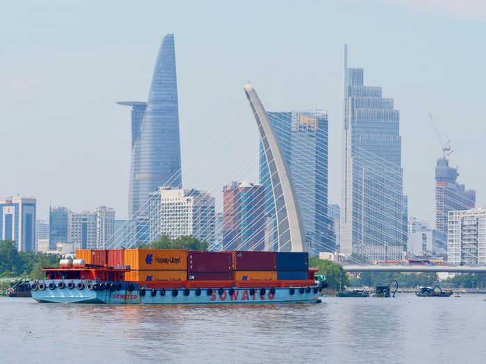 Sà lan chở container lưu thông trên sông Sài Gòn, qua khu vực cầu Ba Son, góp phần tạo nên nhịp giao thương sôi động của TPHCM. Ảnh: HOÀNG HÙNG