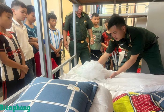 Cán bộ Đồn Biên phòng Yên Khương hướng dẫn học sinh sắp xếp chăn, màn. Ảnh: Xuân Lâm