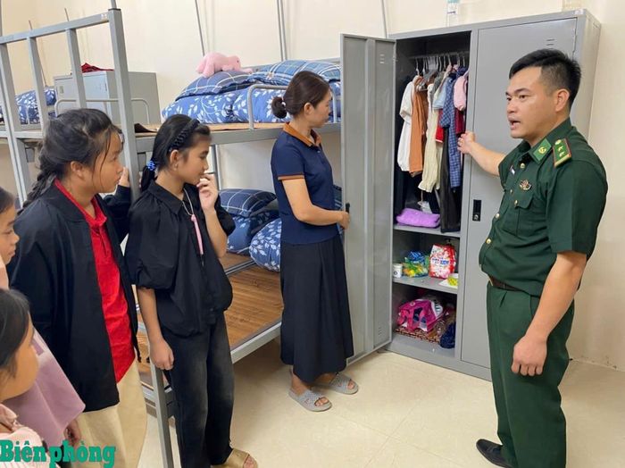 Cán bộ Đồn Biên phòng Yên Khương hướng dẫn học sinh sắp xếp chăn, màn và đồ dùng cá nhân tại phòng ở. Ảnh: Xuân Lâm