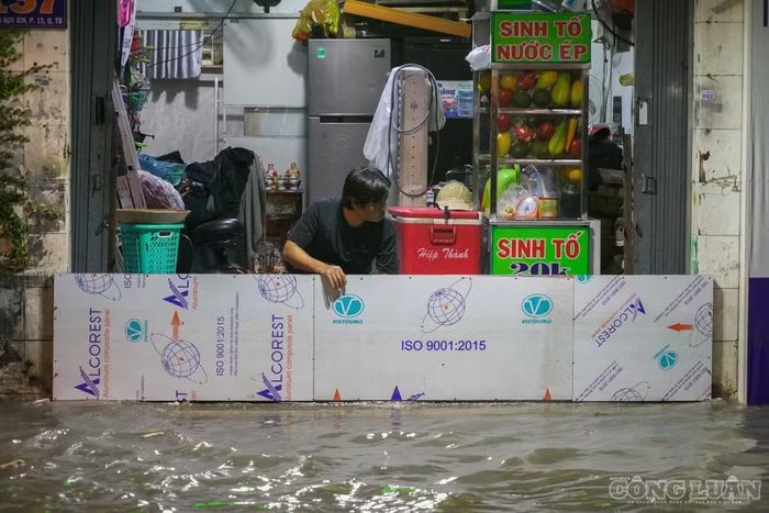 Người dân chật vật ngăn nước tràn vào nhà.