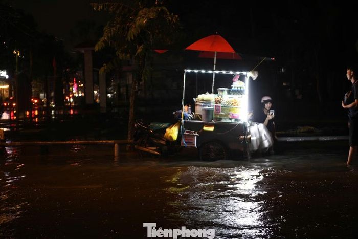 Không chỉ hoạt động kinh doanh bị đình trệ, nhiều người đi đường cũng phải tấp vào trú mưa và chờ nước rút mới dám về nhà.