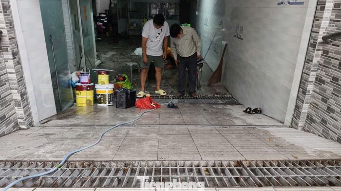 Người dân tranh thủ dọn dẹp, vệ sinh khu vực tầng hầm sau trận mưa lớn.