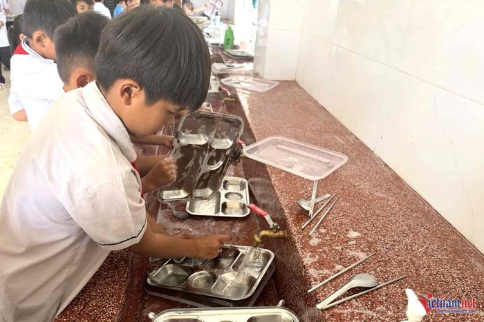 Học sinh tự giác rửa khay đựng thức ăn để bàn giao cho nhà bếp. Ảnh: Hải Dương