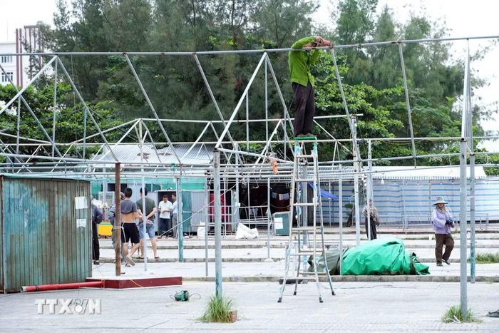 Các hộ kinh doanh thu gom, sắp xếp bàn ghế, thiết bị và vật dụng trước khi vận chuyển khỏi khu vực bãi biển Nhật Lệ. (Ảnh: Tá Chuyên/TTXVN)