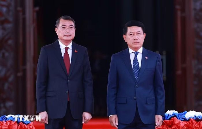 Thủ tướng Lê Minh Hưng và Thủ tướng Lào Saleumxay Kommasith nghe Quân nhạc cử Quốc thiều hai nước. (Ảnh: Dương Giang/TTXVN)