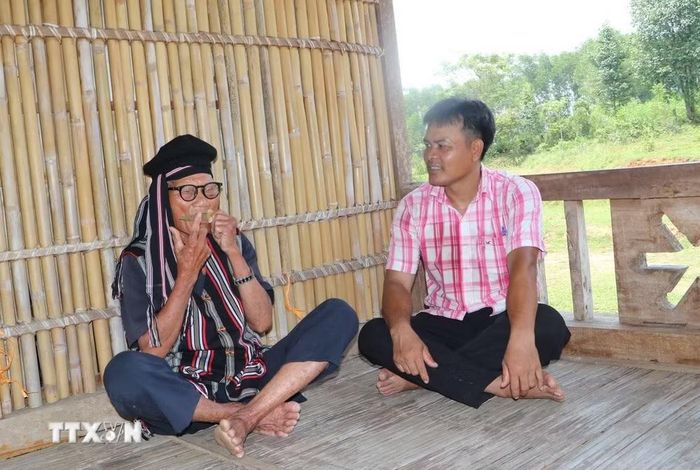 Ông Nguyên thổi đàn Ra ngói và hướng dẫn cách thổi đàn Ra ngói. (Ảnh: Đinh Hương/TTXVN)