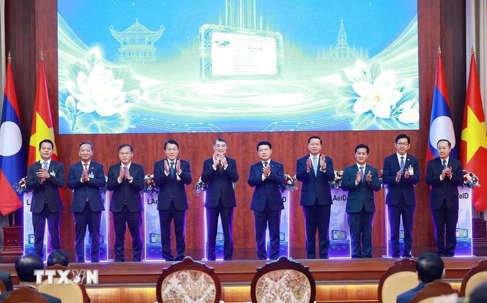 Thủ tướng Lê Minh Hưng và Thủ tướng Lào Saleumxay Kommasith thực hiện nghi thức bàn giao Hệ thống quản lý dân cư và căn cước công dân tại Lào. (Ảnh: Dương Giang/TTXVN)