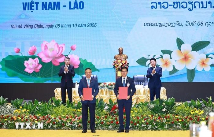 Thủ tướng Lê Minh Hưng và Thủ tướng Lào Saleumxay Kommasith chứng kiến trao chứng nhận và thoả thuận hợp tác đầu tư giữa doanh nghiệp hai nước. (Ảnh: Dương Giang/TTXVN)
