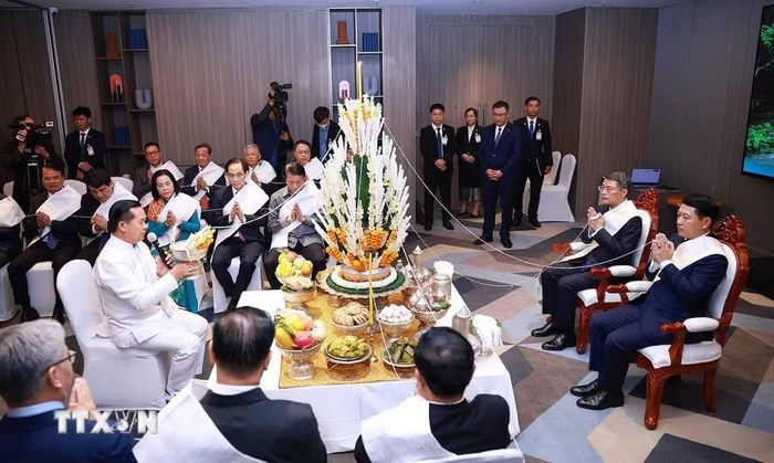 Thủ tướng Lê Minh Hưng và Thủ tướng Lào Saleumxay Kommasith dự Lễ buộc chỉ cổ tay truyền thống của Lào. (Ảnh: Dương Giang/TTXVN)