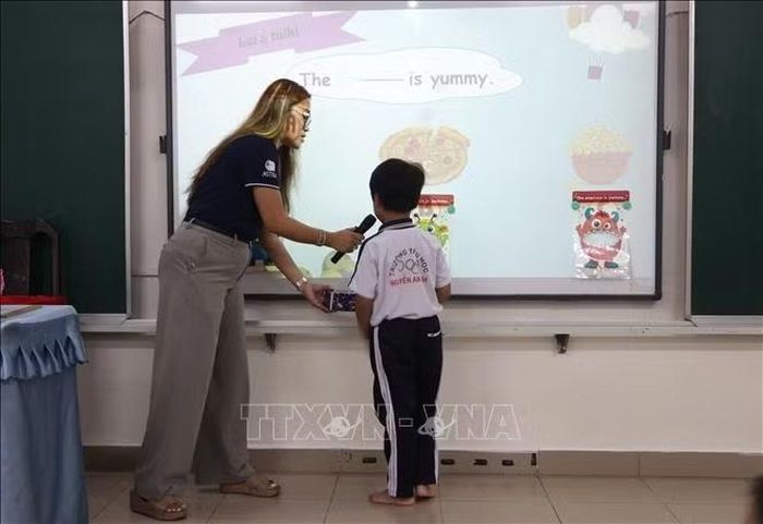 Học sinh lớp 1, Trường tiểu học Nguyễn An Ninh (thành phố Đồng Nai) tự tin giao tiếp tiếng Anh đơn giản với giáo viên nước ngoài.