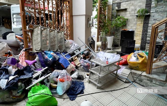 Người dân thu dọn đồ đạc sau trận ngập.