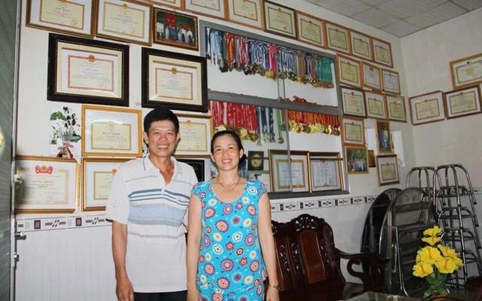 Bố mẹ của Ánh Viên chụp ảnh bên cạnh những thành tích của con gái. Ảnh: Huỳnh Xây