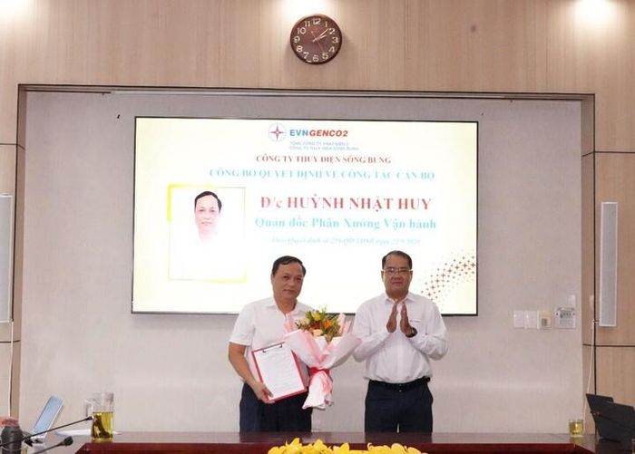 Ông Nguyễn Thành Trung, Bí thư Đảng ủy, Giám đốc Công ty trao quyết định và tặng hoa chúc mừng đồng chí Huỳnh Nhật Huy.