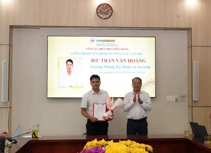 Ông Nguyễn Thành Trung – Bí thư Đảng ủy, giám đốc Công ty trao quyết định và tặng hoa chúc mừng đồng chí Trần Văn Hoàng