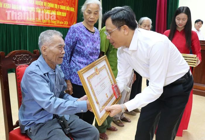 Đồng chí Lê Văn Phúc, Bí thư Đảng ủy, Chủ tịch HĐND xã Hoằng Tiến trao huy hiệu Đảng cho các đảng viên.