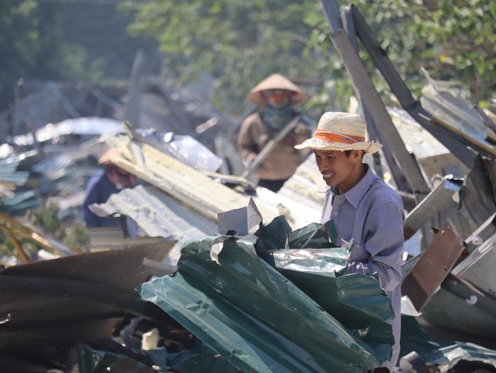 Tại hiện trường, lực lượng chức năng phối hợp cùng người dân và công nhân khẩn trương thu gom tài sản, tháo cắt khung sắt, mái tôn và bốc xếp phế liệu lên xe chuyên dụng nhằm nhanh chóng hoàn trả lại mặt bằng sạch cho đô thị.