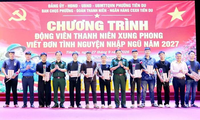 Đại diện Bộ Chỉ huy quân sự thành phố Bắc Ninh trao quà cho các thanh niên phường Tiên Du viết đơn tình nguyện.