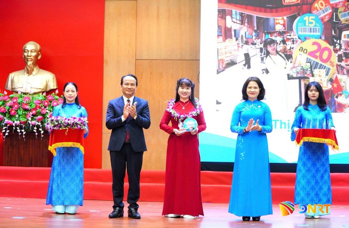 Phó Bí thư Thành ủy, Chủ tịch Ủy ban MTTQ Việt Nam thành phố Nguyễn Đình Vĩnh (thứ 2, từ trái qua) và Chủ tịch Hội Liên hiệp Phụ nữ thành phố Hoàng Thị Thu Hương (thứ 2, từ phải qua) trao biểu trưng và hoa tôn vinh gương phụ nữ làm kinh tế giỏi. Ảnh: VINH ANH