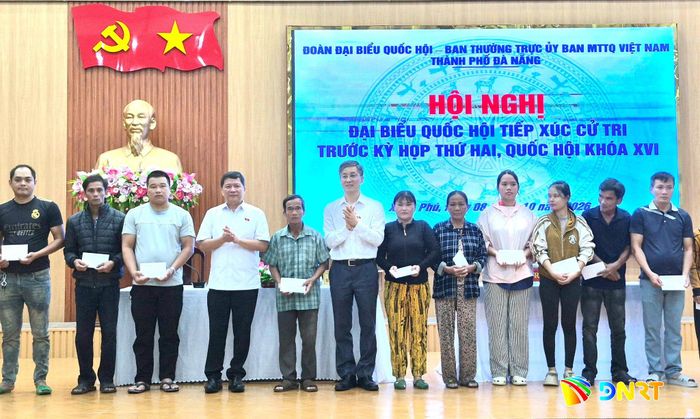 Các đại biểu Quốc hội Tạ Văn Hạ (thứ 4, trái sang) và Nguyễn Khánh Ngọc (thứ 6, trái sang) trao quà hỗ trợ người nghèo, người có hoàn cảnh khó khăn của xã Xuân Phú tại buổi tiếp xúc. Ảnh: QUỐC TUẤN