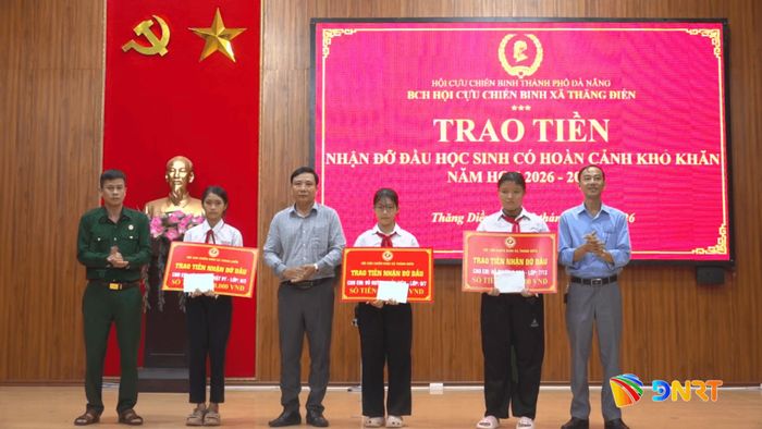 Lãnh đạo xã Thăng Điền và đại diện Hội Cựu chiến binh xã trao kinh phí hỗ trợ cho 3 học sinh. Ảnh: GIANG BIÊN