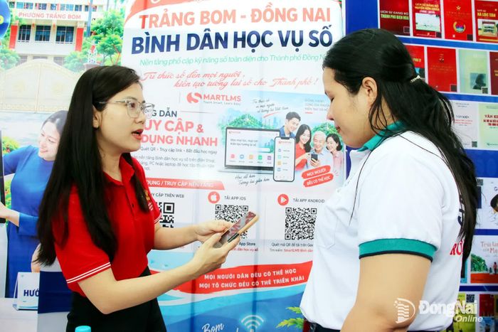 Chuyên viên Trung tâm Phục vụ hành chính công phường Trảng Bom hỗ trợ người dân cài đặt ứng dụng học trực tuyến Bình dân học vụ số vào đầu tháng 10-2026. Ảnh: Hải Quân