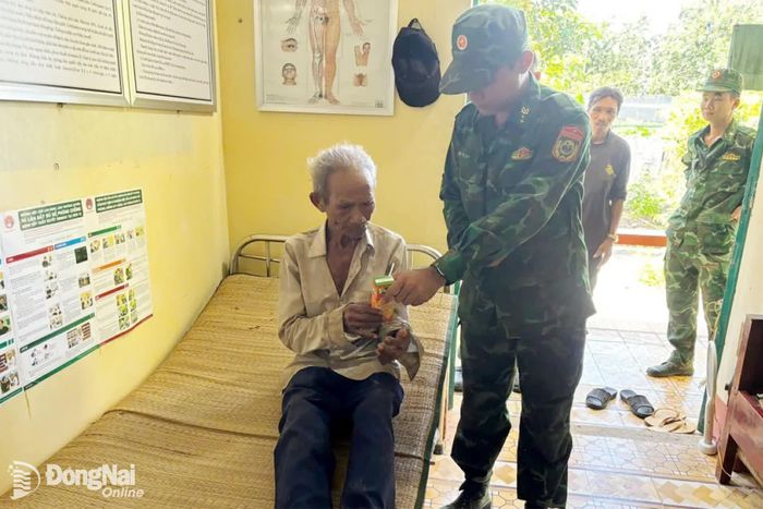 Quân y Đồn Biên phòng Lộc Thành hỏi thăm sức khỏe ông Điểu Cầm. Ảnh: ĐVCC