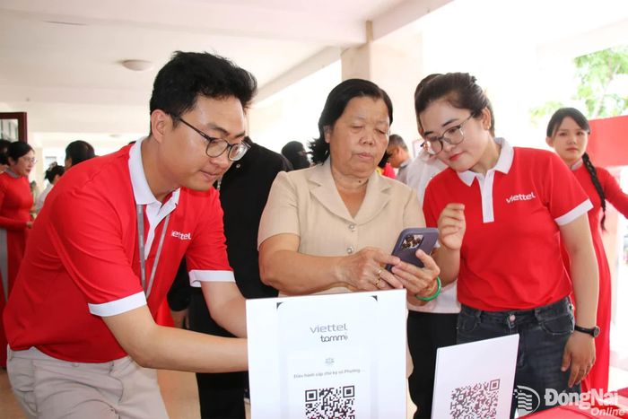 Nhân viên của Viettel Đồng Nai hướng dẫn người dân cài đặt và kết nối nền tảng Tammi OA - Chính quyền số phường Trấn Biên. Ảnh: Hải Quân