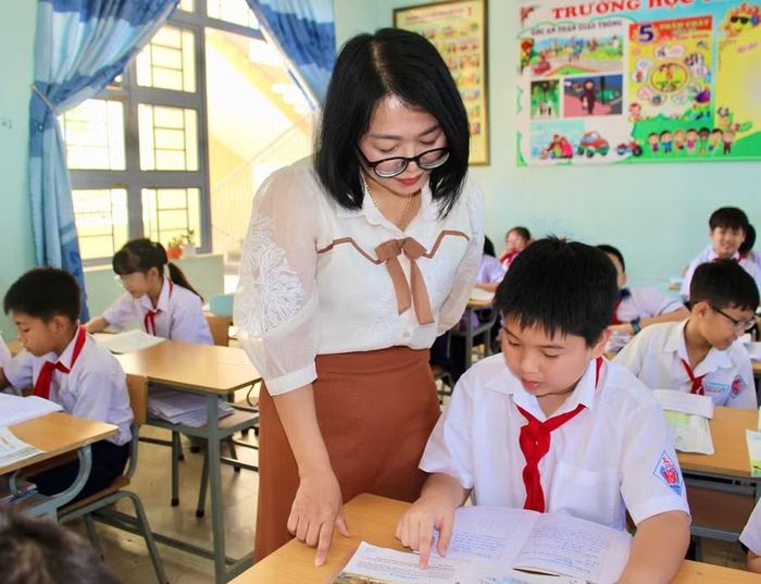  Cô Trương Thị Cẩm Lai hướng dẫn Cao Thanh Phong làm bài trong giờ học tại lớp. Ảnh: M.C 