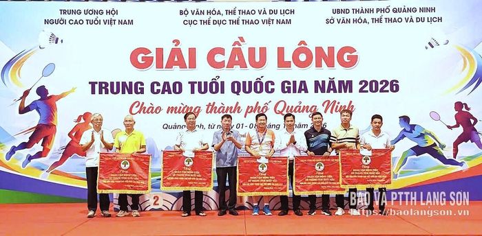 Đại diện đoàn VĐV Lạng Sơn (áo cam đứng giữa) nhận cờ lưu niệm Trung ương Hội Người cao tuổi Việt Nam trao tặng cho đoàn có thành tích xuất sắc tại giải (ảnh do VĐV cung cấp)