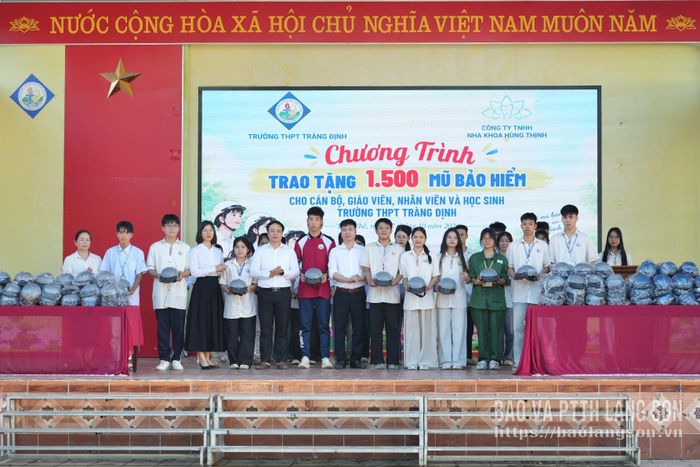 Đại diện Công ty TNHH Nha khoa Hùng Thịnh tặng mũ bảo hiểm cho Ban giám hiệu và học sinh Trường THPT Tràng Định