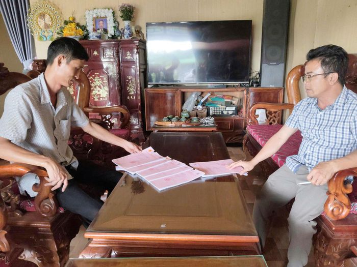 Anh Đỗ Trọng Nam (bên trái) vỡ òa hạnh phúc khi làm được 5 sổ đỏ sau nhiều năm đợi chờ