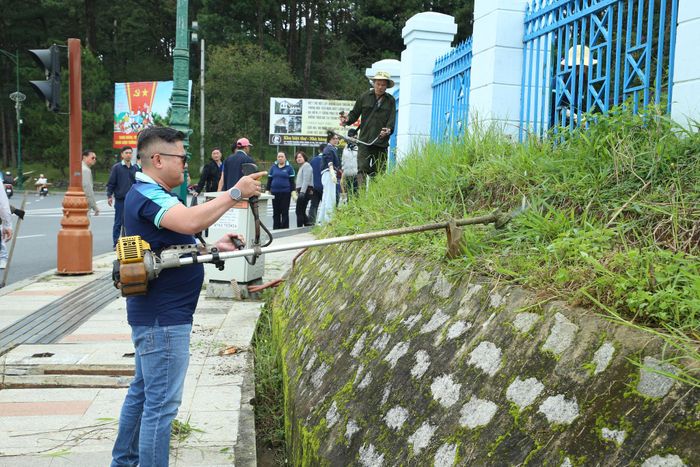 Đoàn viên Công đoàn Báo và Phát thanh, Truyền hình Lâm Đồng cắt cỏ phía ngoài khuôn viên cơ quan