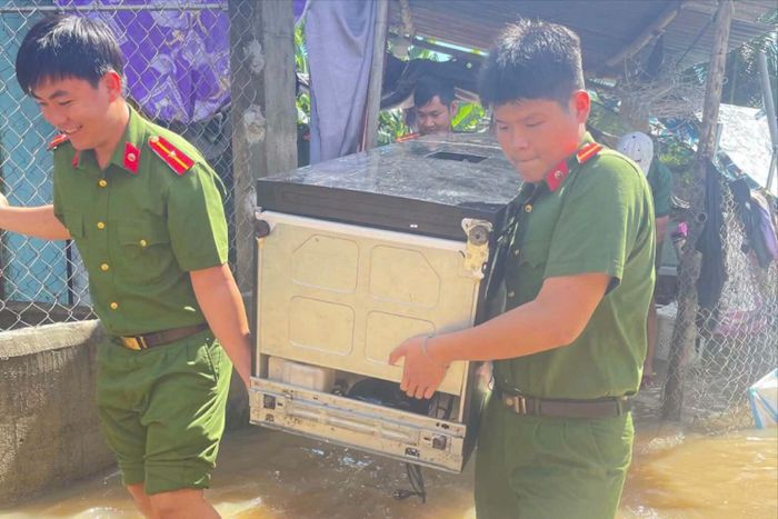 Công an xã Bắc Bình giúp dân di chuyển tài sản ra khỏi vùng bị ngập