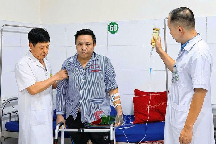 Bác sĩ Trần Hồng Vinh (bên trái) cùng đồng nghiệp hướng dẫn bệnh nhân tập phục hồi vận động.Ảnh PV