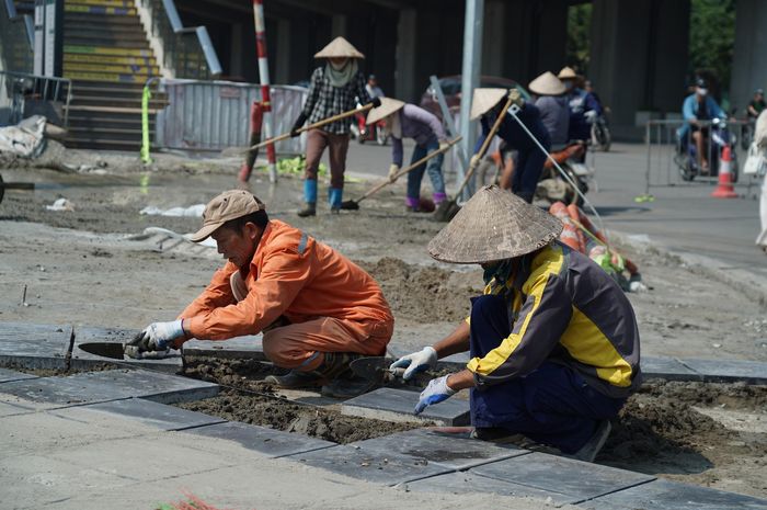 Theo ghi nhận của phóng viên Báo Xây dựng, đoạn đường Vành đai 2,5 từ Nguyễn Trãi đến Đầm Hồng, công nhân đang khẩn trương thi công hoàn thiện lát đá vỉa hè để kịp thông xe kỹ thuật vào dịp kỷ niệm Ngày Giải phóng Thủ đô 10/10.
