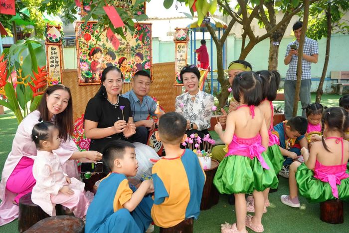 Các em nhỏ trải nghiệm không gian văn hóa truyền thống cùng cô giáo và cha mẹ học sinh.