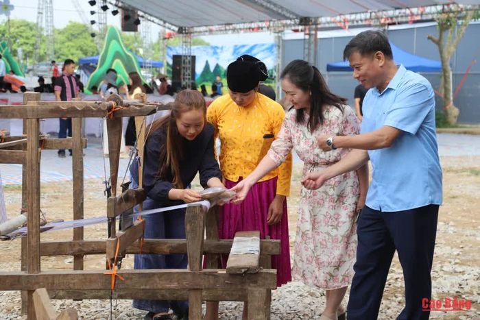 Đại biểu tham quan, tìm hiểu khung dệt của người Mông tại gian trưng bày của tỉnh Cao Bằng.