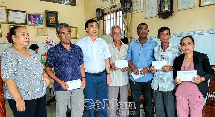  Bí thư Đảng uỷ xã Hoà Bình Hồ Văn Linh (thứ 3 từ trái sang), trao quà cho người có uy tín và gia đình chính sách tại chùa Hoà Bình mới.