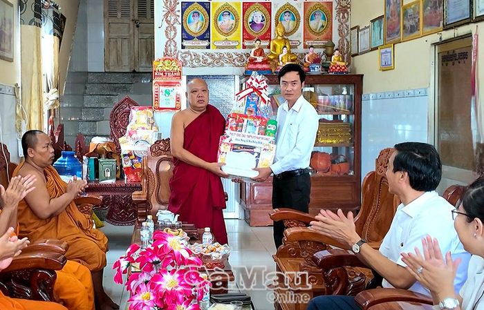 Phó Giám đốc Sở Dân tộc và Tôn giáo Lương Văn Pho trao quà của Tỉnh uỷ, HĐND, UBND, Uỷ ban MTTQ Việt Nam tỉnh Cà Mau chúc mừng đến Đại đức Danh Dần, Trụ trì chùa Hoà Bình mới.