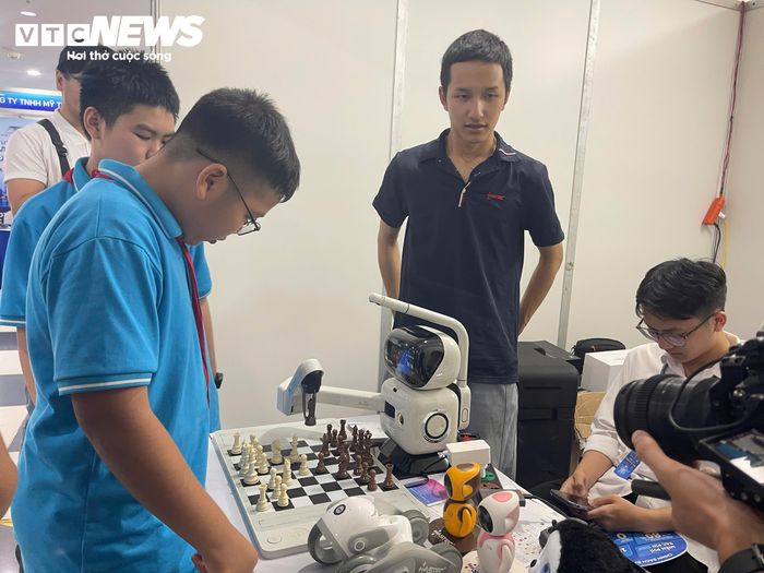 Các em nhỏ được đấu trí với robot đánh cờ tại Triển lãm. (Ảnh: Đỗ Huệ)
