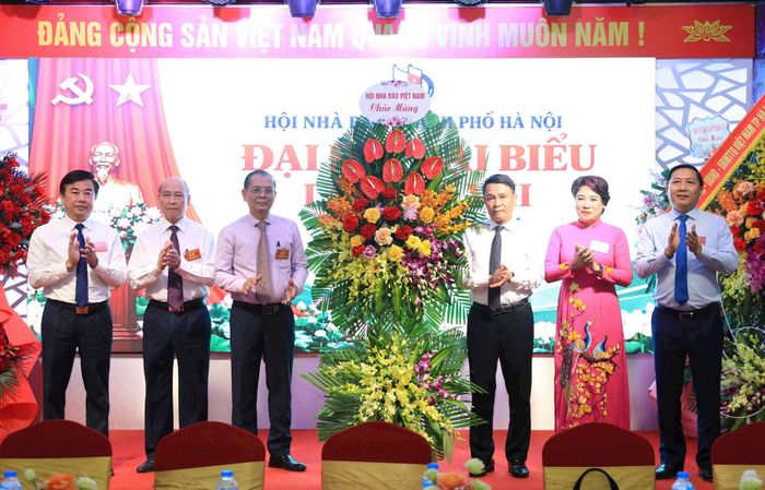 Phó Chủ tịch Thường trực Hội Nhà báo Việt Nam Nguyễn Đức Lợi thay mặt Hội Nhà báo Việt Nam tặng hoa cho Hội Nhà báo thành phố Hà Nội. Ảnh: Quang Thái.